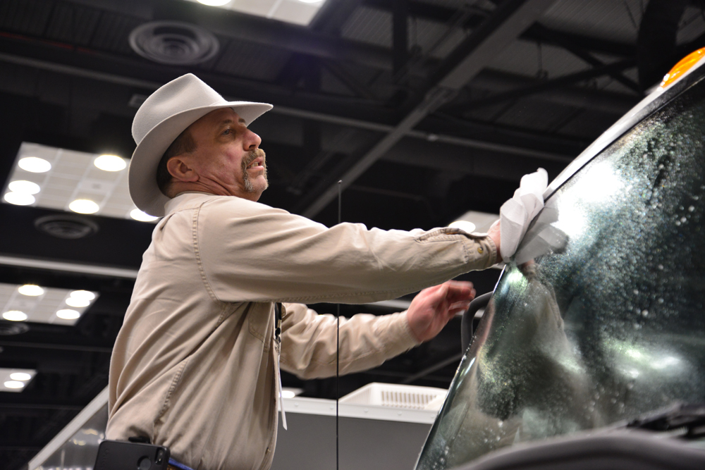 Workers shine and polish trucks and tanks once they're parked in booths.